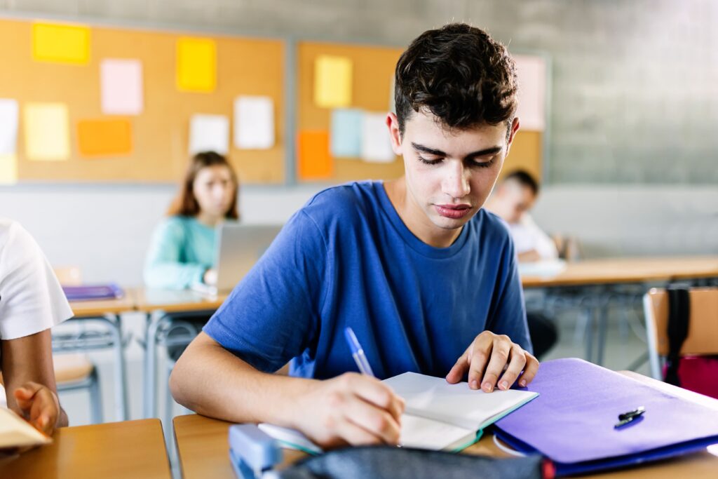 estudiante universitario tomando apuntes en clase